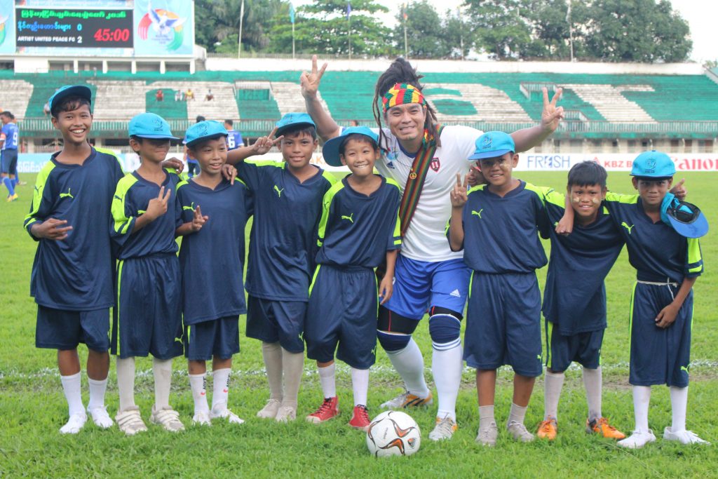 Reggae singer Saw Phoe Kwar with the ball boys from the match. (Photo: Libby Hogan / DVB)